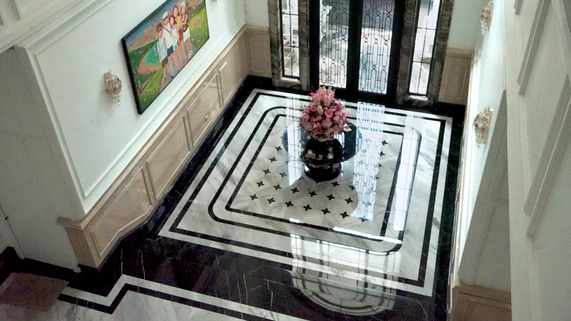 Tampak atas lantai foyer marmer rumah Mr. H, pola inlay bintang terlihat utuh dari lantai dua